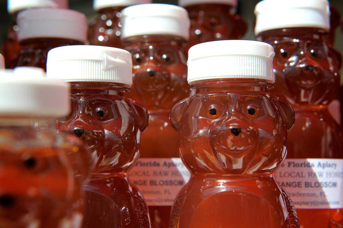 Bear-shaped plastic honey jars filled with raw honey from the Pure Florida Apiary of Bradenton.