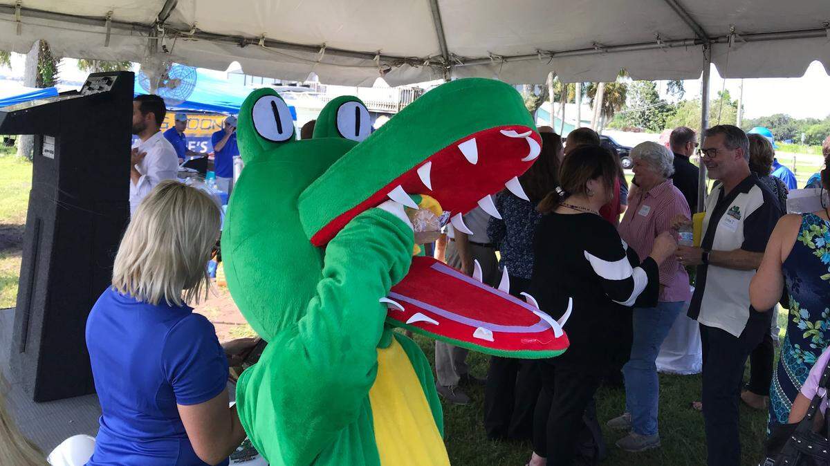 Whiskey Joe’s Bar and Grill gator mascot takes a drink of cold water trying to stay cool during the restaurant’s groundbreaking in Ellenton on Wednesday. Shown at right, Speciality Restaurant’s CEO and president John Tallichet talks to Manatee County Commissioner Misty Servia.