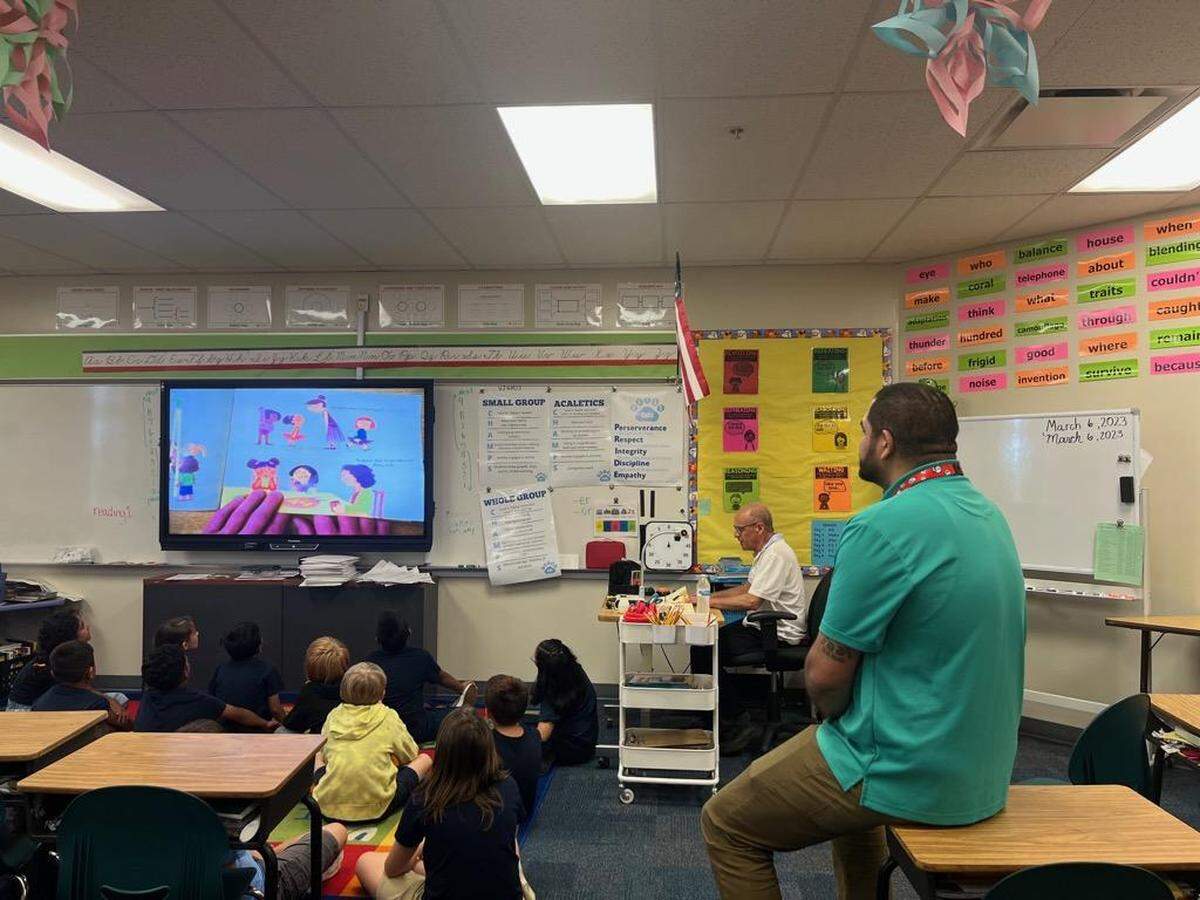 Daniel Munive’s third-grade class at Bayshore Elementary School looks on as volunteer Richard Parr reads to the class on Tuesday, March 7, 2023.