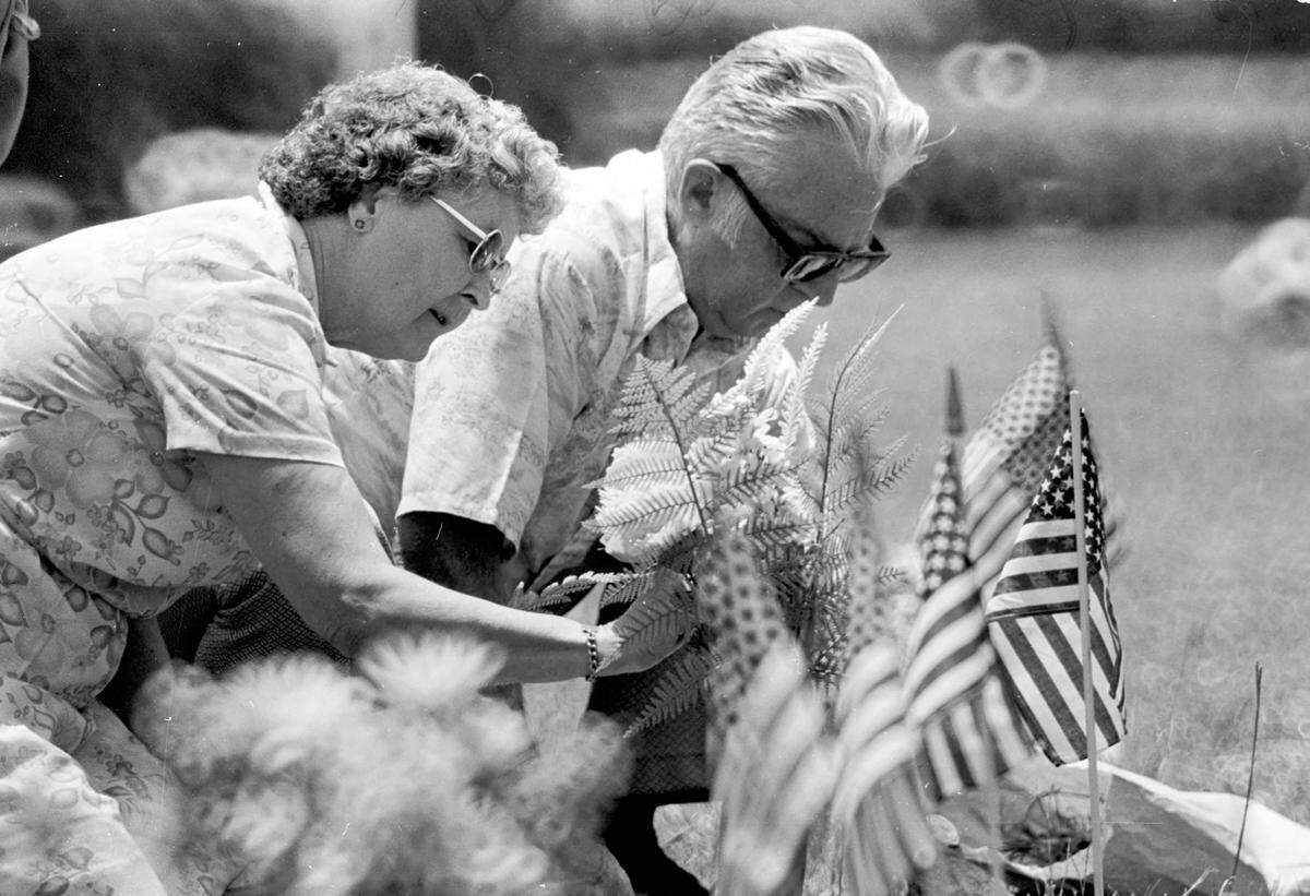 A man and woman place flags and flowers on veterans’ graves for Memorial Day 1979.