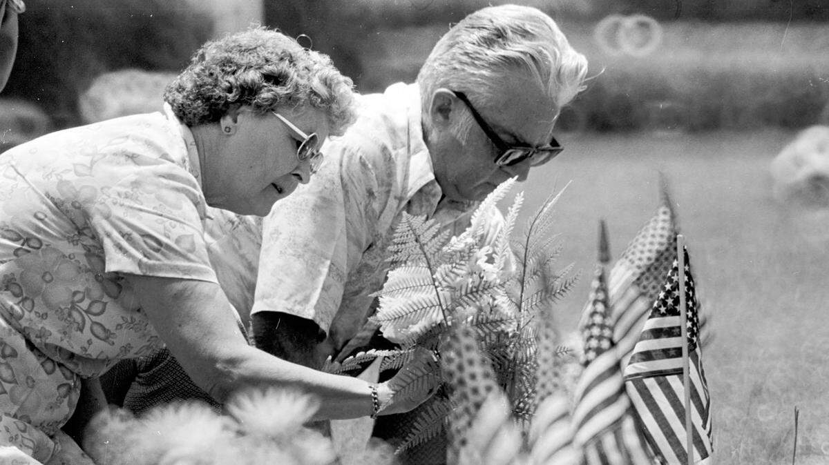 A man and woman place flags and flowers on veterans’ graves for Memorial Day 1979.
