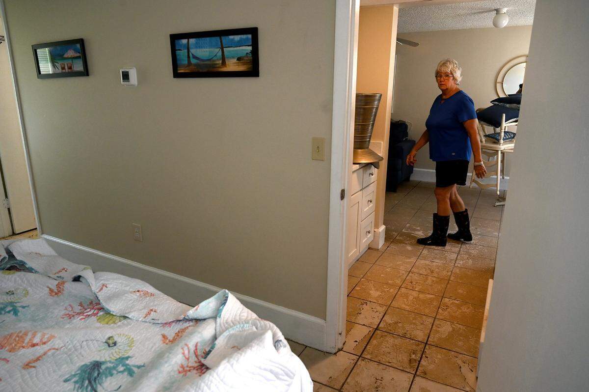 Lori Calderone, manager of the Anna Maria Motel Resort, cleans one of the rooms with water damage after Hurricane Idalia passed, on August 31, 2023.
