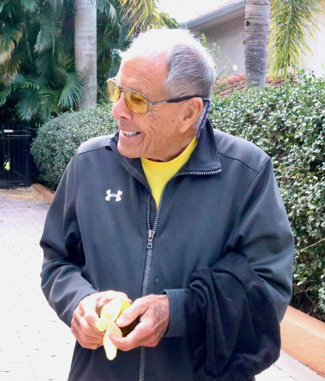 01/07/2021--As he nears 90, Nick Bollettieri and his wife, Cindi, have their house on the market to move closer to IMG Academy. He has a new book on the way and is stepping up his program to bring tennis to the inner city. He is shown above peeling an orange he just picked off a tree in his backyard.