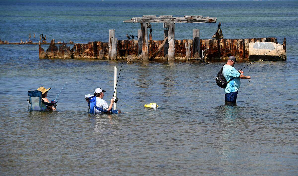 03/30/21--Site operators at Piney Point, the former phosphate mine, have begun a controlled release of up to 480 million gallons of contaminated water into a channel at Port Manatee due to a leak in a holding pond. A family fishes in the waters adjacent to the port.