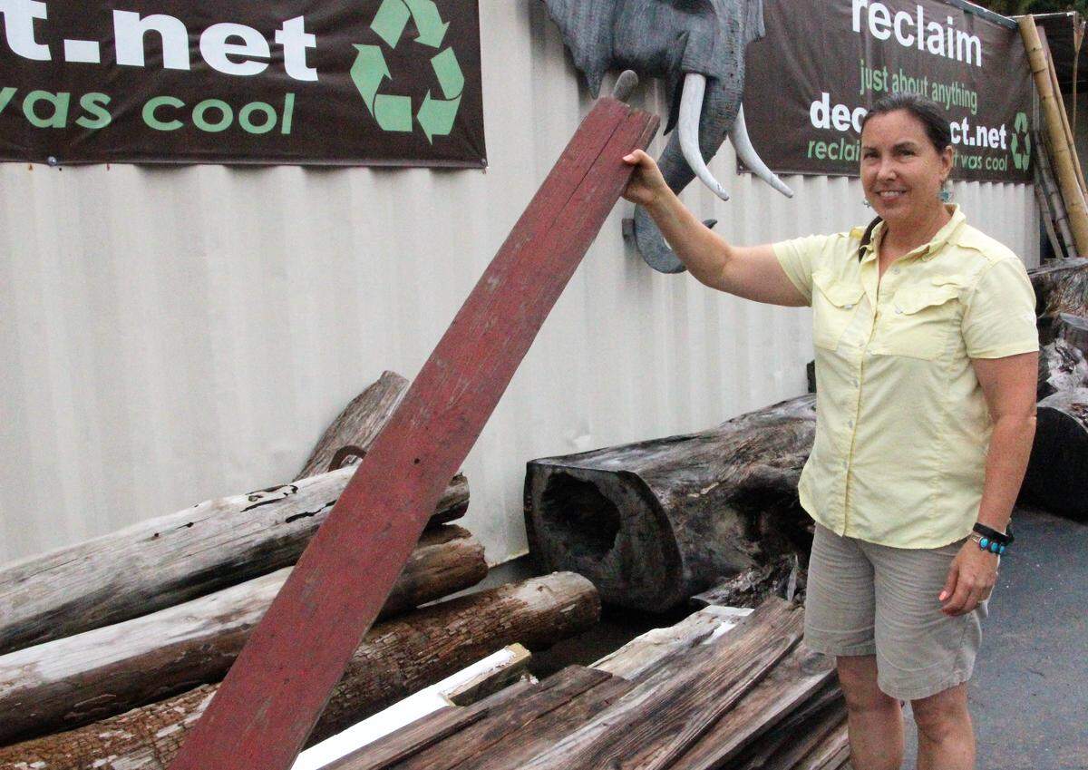Celeste Gruenstein shows lumber harvested from a north Florida tobacco barn that will find new life as a room accessory or in furniture.