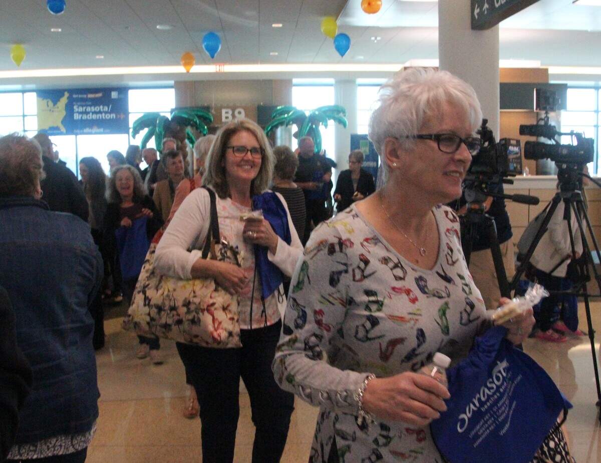 Smiling Allegiant passengers enter the terminal  at Sarasota Bradenton International Airport on Wednesday. They were among the first arrivals on low-cost carrier Allegiant's inaugural flight from Indianapolis.