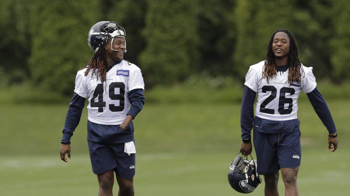 Seattle Seahawks linebacker Shaquem Griffin, left, walks with his twin brother, cornerback Shaquill Griffin, right, following NFL football practice, Thursday, June 14, 2018, in Renton, Wash.