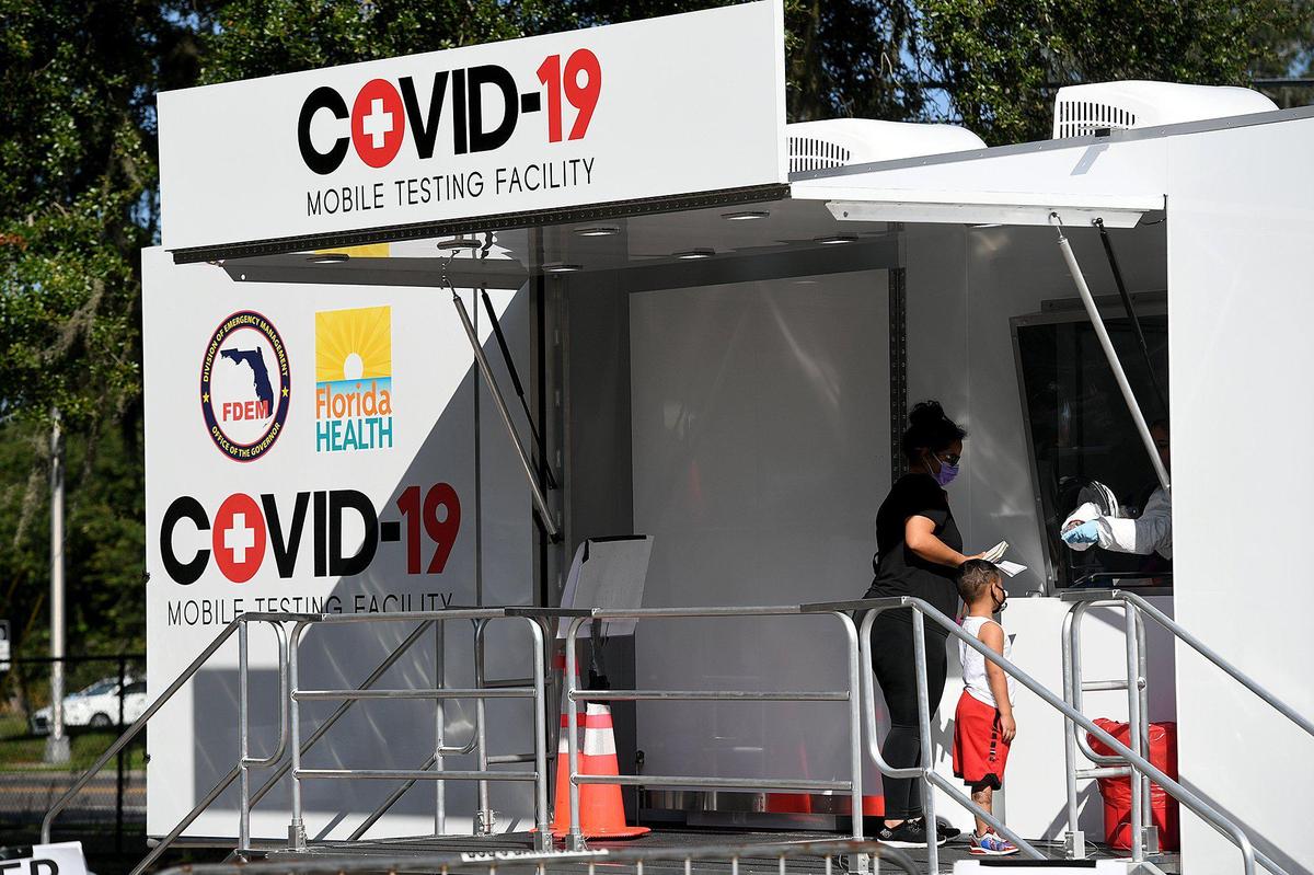 Angelica Lebron and her son, Ezekiel Rosales, 4, get free COVID-19 testing sponsored by the State of Florida at Lincoln Park in Palmetto.