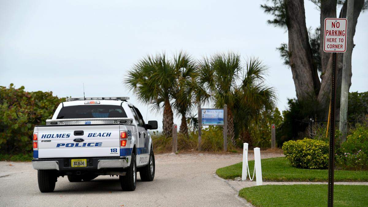 A Holmes Beach police truck drives down a road with limited parking spaces. A meeting between Holmes Beach city commissioners and Manatee County commissioners to discuss parking problems on the island failed to find a resolution during the first meeting since parking spaces were removed in 2020.