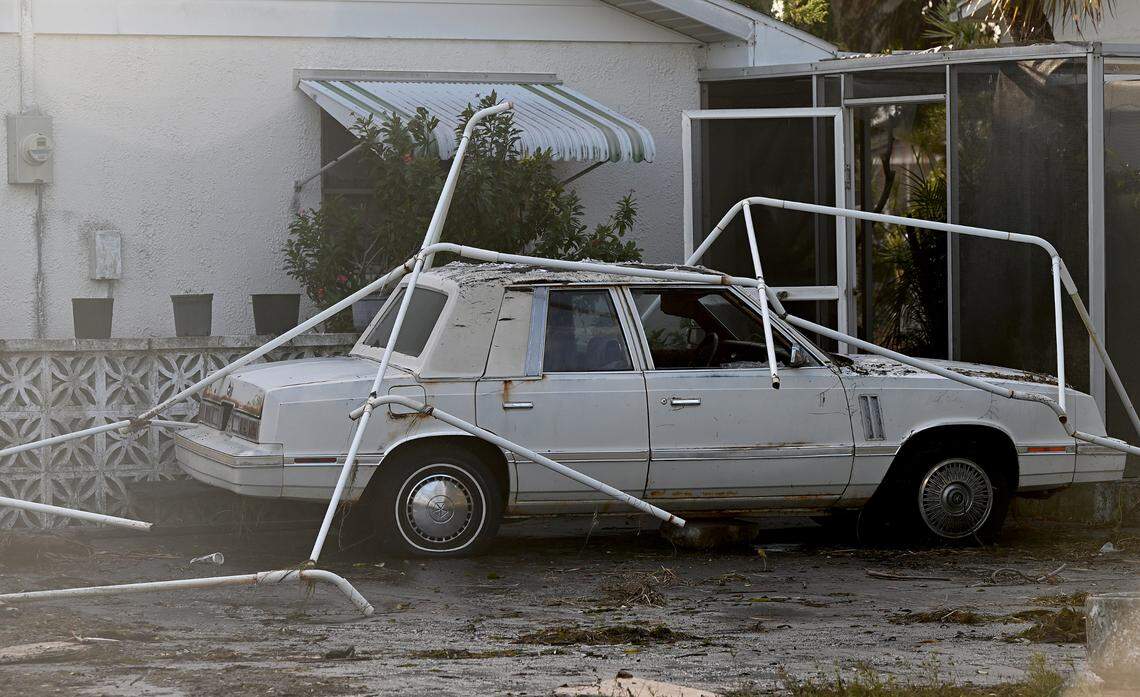The remains of a carport lay upon a car in Bradenton in the aftermath of Hurricane Helene in Manatee County on Friday, Sept. 27, 2024.