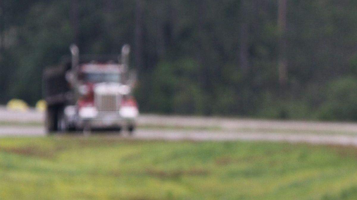 A Department of Transportation employee picks up trash along a highway. 
 AP file photo