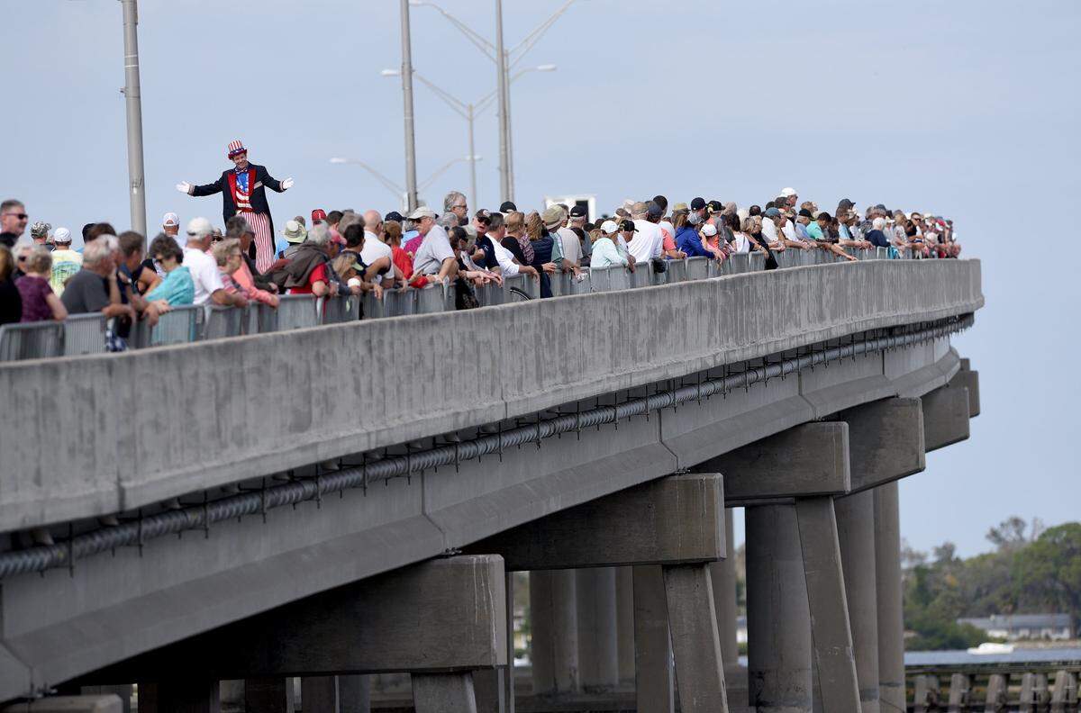 A man in stilts walks through the crowds gathered on the Green Bridge at the Bradenton Area River Regatta.