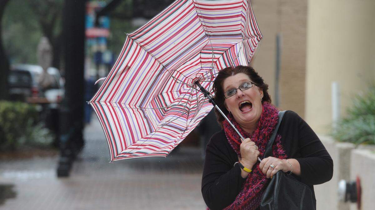 Lisa Rivera reacts as her umbrella blows in a gust of wind as she walks along Old Main Street, as a front moves over Manatee County on Friday, bringing cooler temperatures and breezy conditions to the area. 
 GRANT JEFFERIES/Bradenton Herald