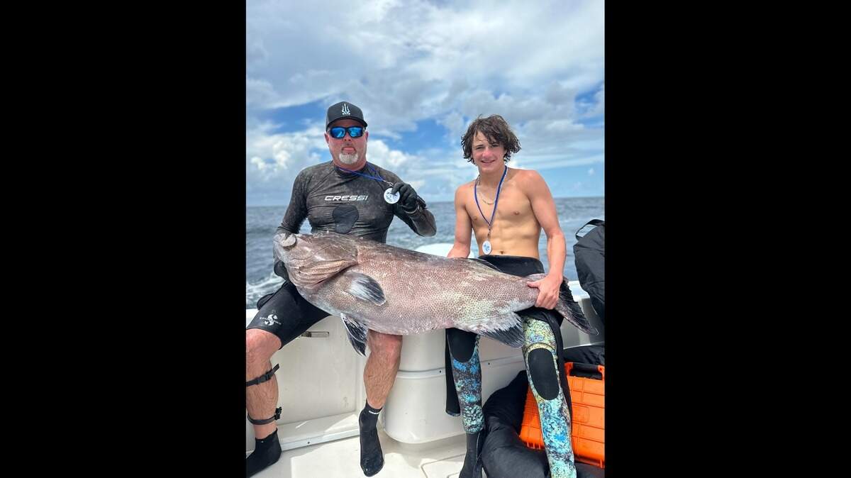 Brett Booth (left) and his son Hudson pose with the first-place black grouper speared during the 58th Annual St. Pete Open spearfishing tournament.