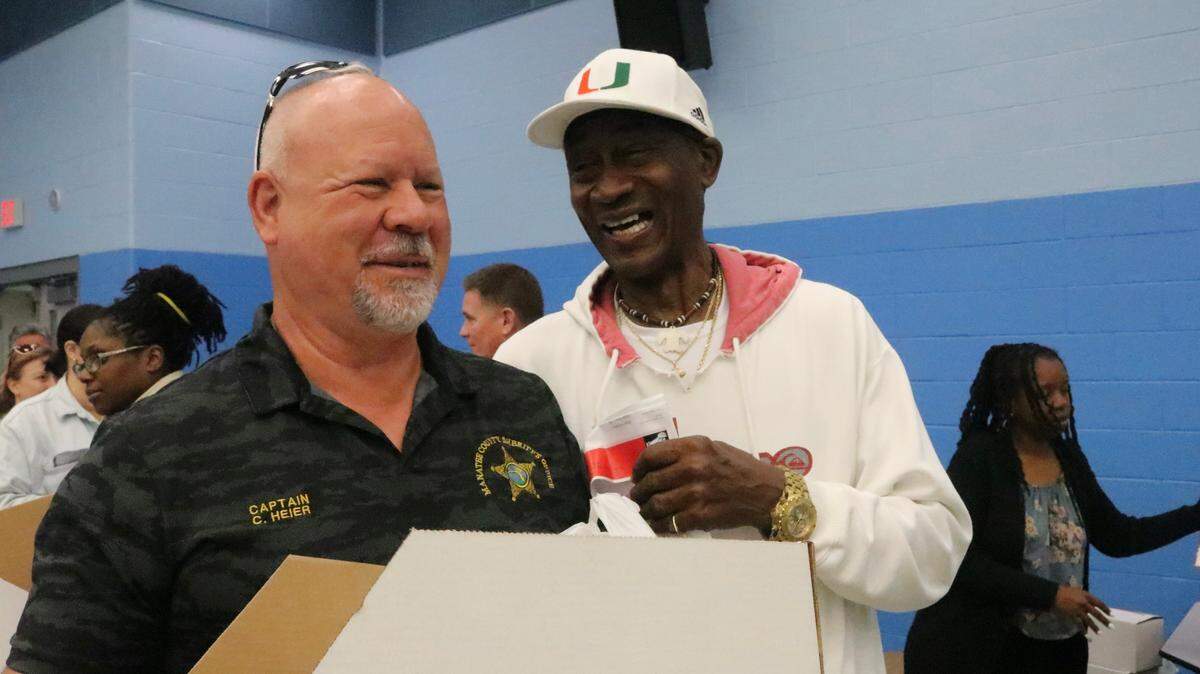 Sports legend Ray Bellamy greets Captain Chris Heier of the Manatee County Sheriff’s Office. Heirer was one of those helping distribute 400 meals to families this week.
