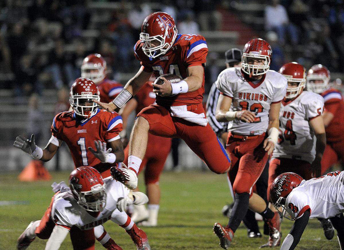 In this Herald file photo, former Manatee High quarterback Cord Sandberg seems to fly over St. Petersburg Northeast’s defense for a touchdown.
