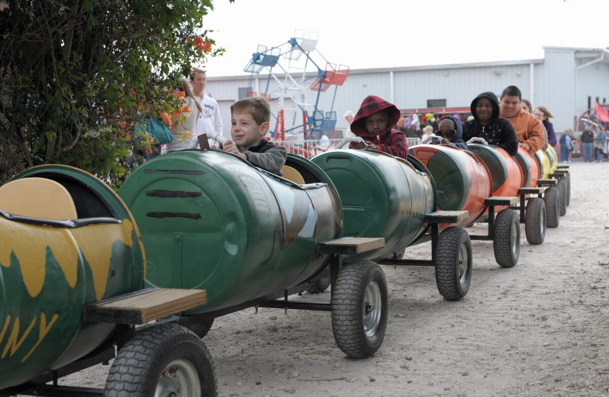Kids and adults enjoy a ride through the groves during the Mixon Fruit Farms Orange Blossom Festival.