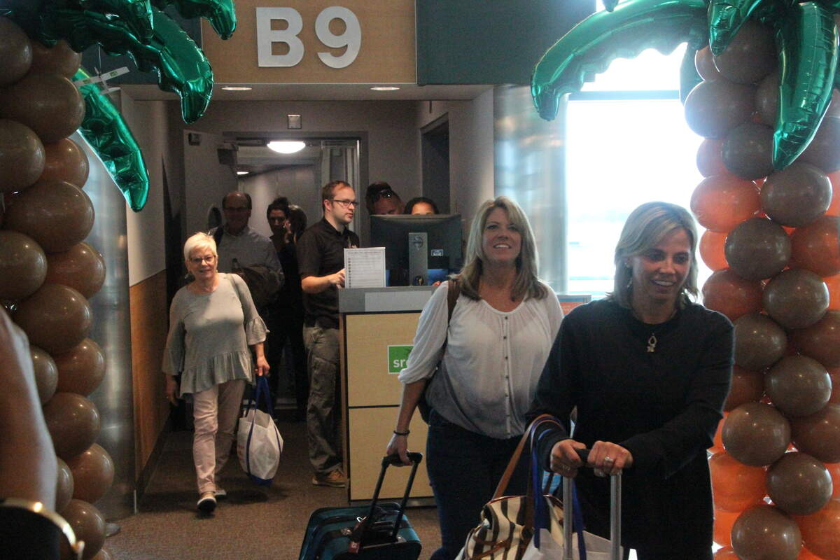 Smiling Allegiant passengers enter the terminal  at Sarasota Bradenton International Airport on Wednesday. They were among the first arrivals on low-cost carrier Allegiant's inaugural flight from Indianapolis.