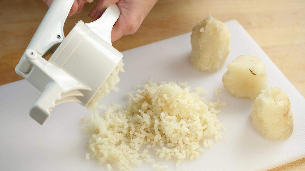 After letting the cooked potatoes cool slightly, peel and pass through a ricer or food mill onto a floured surface. (Michael Tercha/Chicago Tribune/TNS)