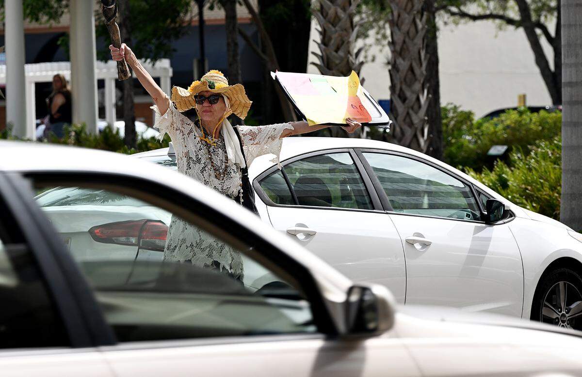 Heidi Crawford protests a parking garage on Anna Maria Island with other demonstrators Friday in downtown Bradenton. Gov. Ron DeSantis signed a law Friday that allows Manatee County to build Anna Maria Island beach parking garage despite protests from residents.