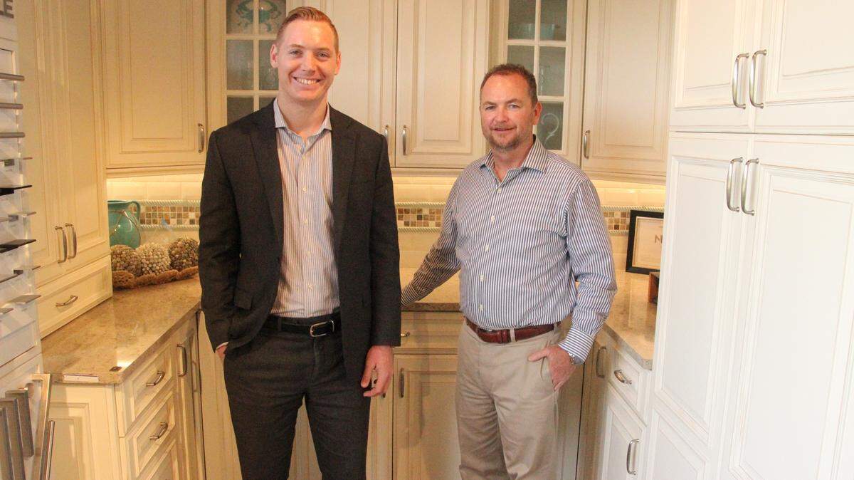 Evan Gilbert and Ernest Gilbert stand in one of Gilbert Design Build’s kitchen models in the company’s showroom on Manatee Avenue.