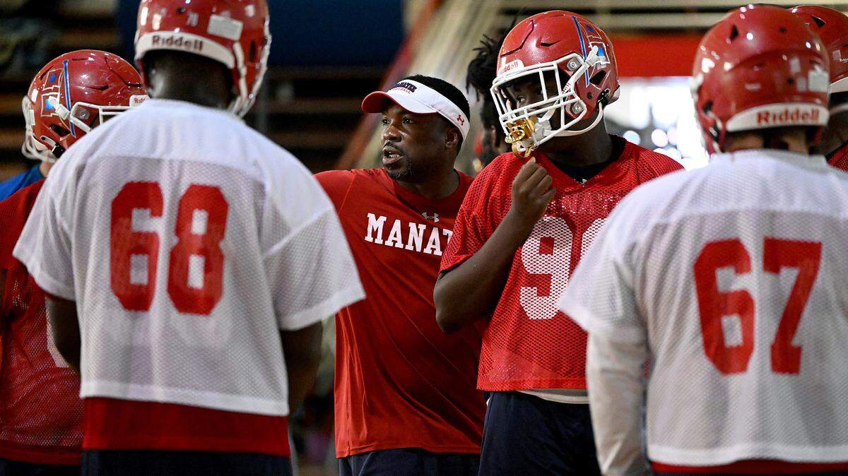 The Manatee Hurricanes High School football team practice indoors in the JROTC gym on the campus as the heat index pushed 94 outside. Coach Jacquez Green works with players.