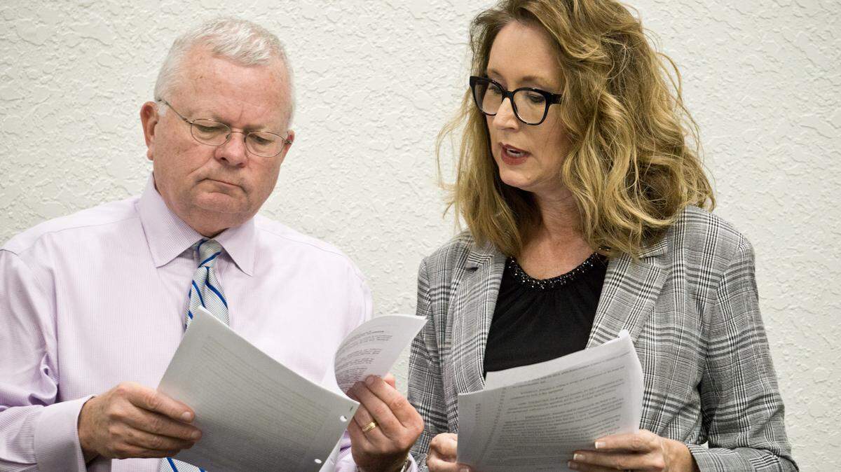 Cynthia Saunders, right, compares two drafts of an interim superintendent contract with school board attorney James Dye.
