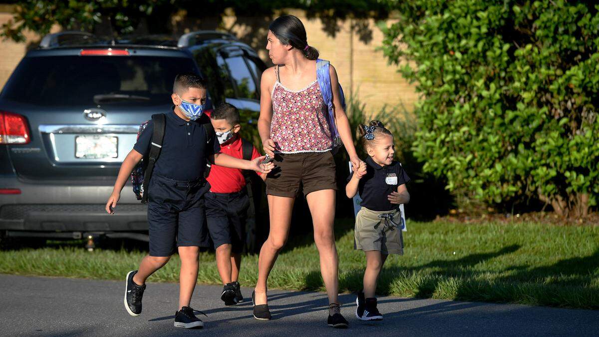 08/09/21—A family watches for traffic on their way to Sea Breeze Elementary on the first day of school in Manatee County.