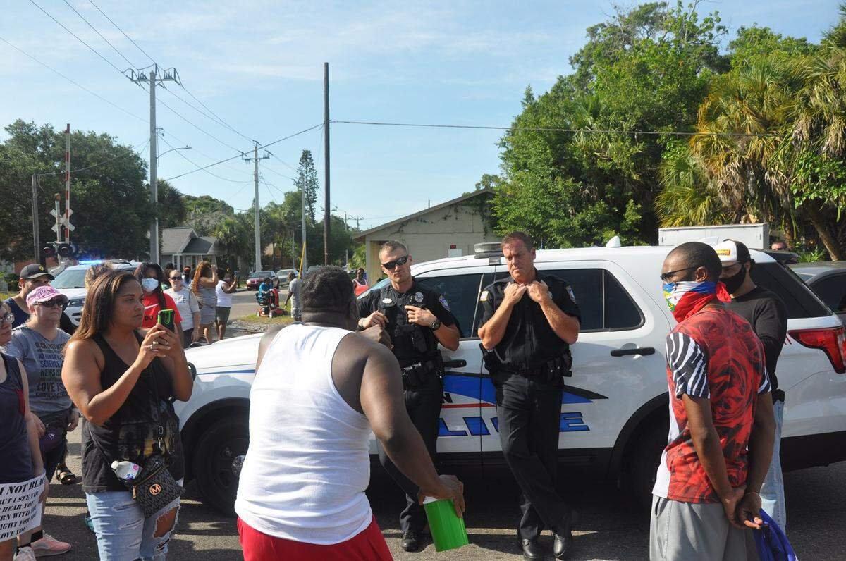 Alton Lilly, in white t-shirt, yells at two Bradenton police officers during Sunday’s march to protest the death of George Floyd in Minnesota.