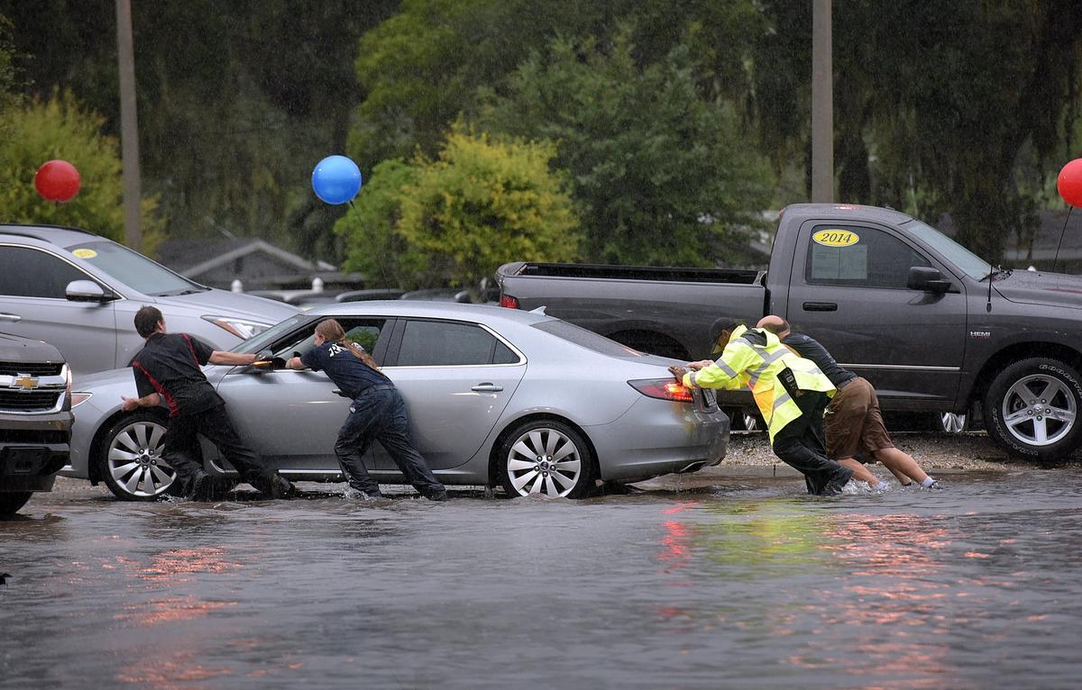 A new stormwater fee that would help pay for infrastructure improvements to reduce flooding in Manatee County is not likely to move forward, officials say. A flooded area at the intersection of 30th Street and Ninth Avenue West is pictured in this Bradenton Herald file photo. A Manatee County Sheriff’s deputy and others joined together to push a stranded motorist from the flooded streets of U.S. 41. in this Bradenton Herald file photo.