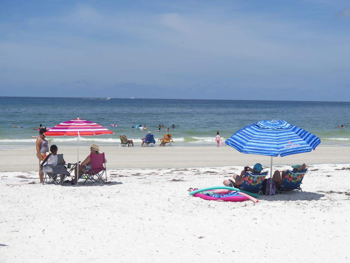 Beachgoers on Anna Maria Island enjoy the sun and the waves despite reports of respiratory irritations. Some visitors said they traveled to Manatee specifically to avoid worse red tide blooms farther south.