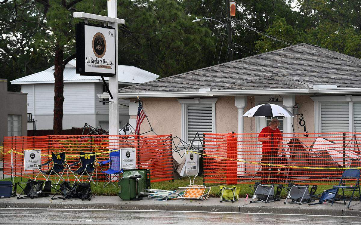A man with an umbrella checks out his collapsed tents on Manatee Avenue after the 2022 De Soto Grand Parade was cancelled because of bad weather.