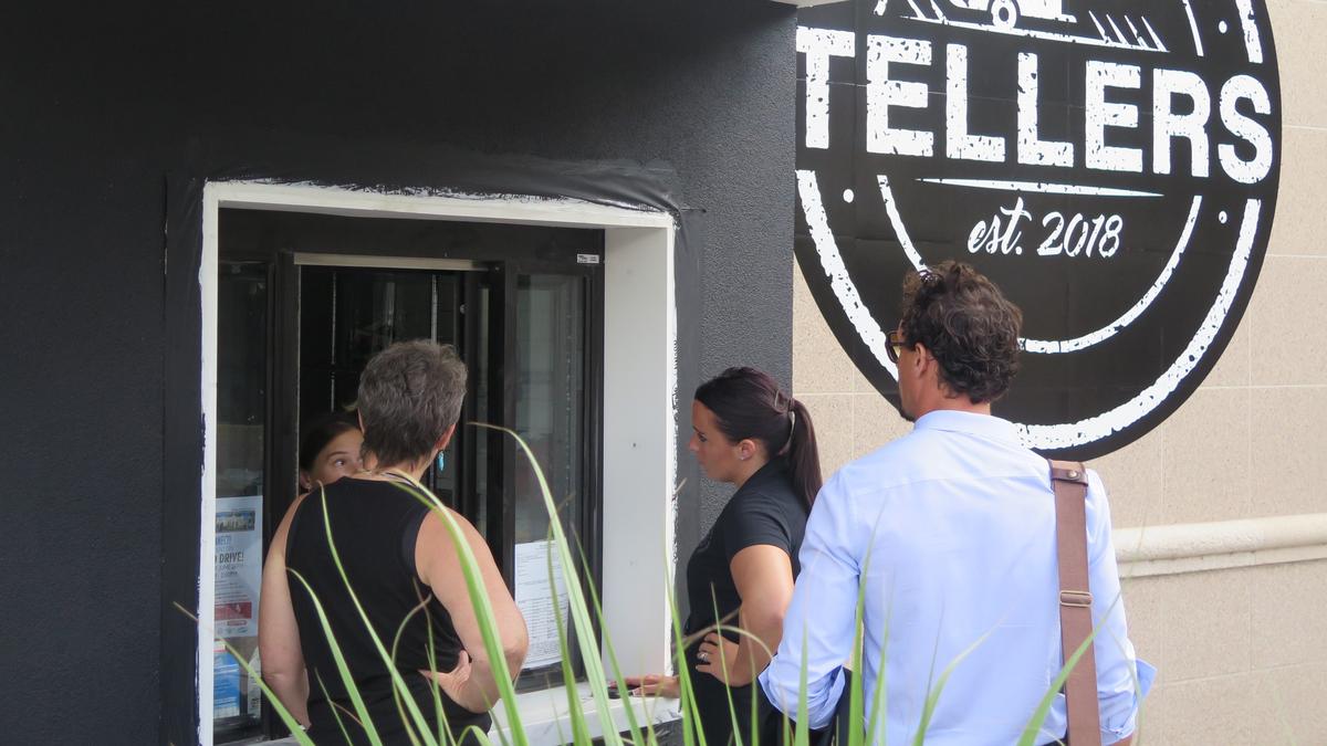 Lauri Contarino speaks with customers through the teller window at her new walk-up coffee spot. Tellers also offers vegan deli-style grab and go foods, and a beer and wine garden is coming soon.