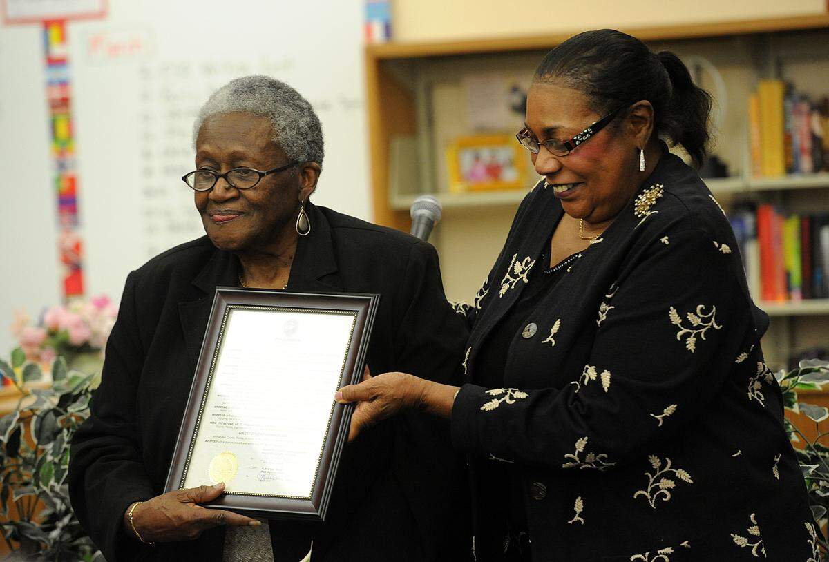 The daughters of Louise Johnson, Cherie Johnson and Johnyta Roundtree, receive a proclamation honoring their mother and Johnson Middle School’s namesake at a special program also honoring past principals and celebrating Black History Month.