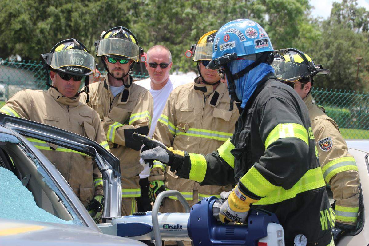 Tim Winkler, in the blue helmet, demonstrates how to use a Hurst Jaws of Life spreader. Watching are firefighters from the Parrish Fire District.