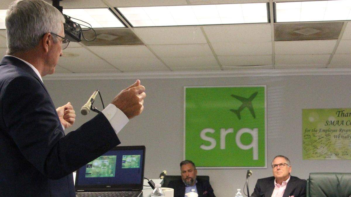 Rick Piccolo, left, gives Sarasota Manatee Airport Authority members an upbeat report on business at Sarasota Bradenton International Airport on Monday. Shown, seated, are Doug Holder and chairman Robert Spencer, right.
