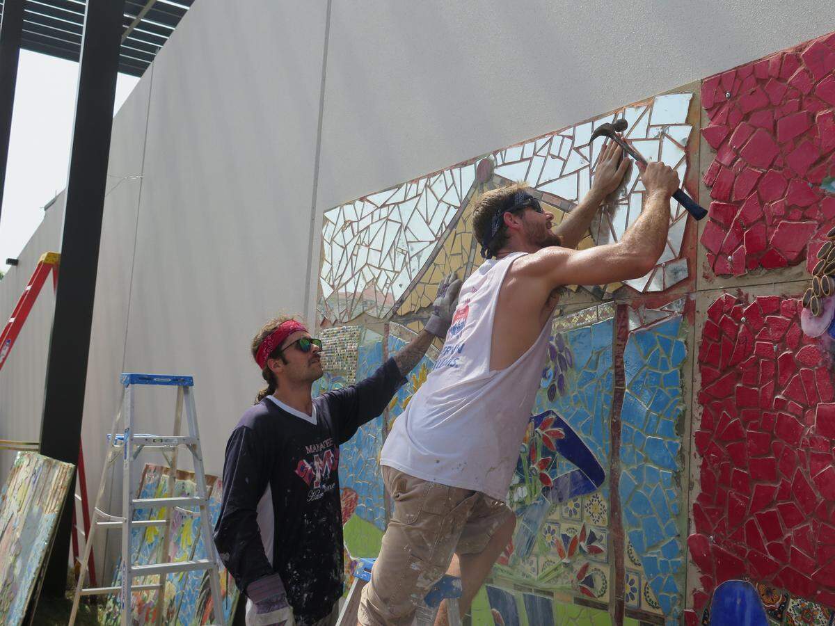 Panels of completed portions of ‘The Magic River’ mosaic mural were installed on the City Centre parking garage Tuesday morning. The work started Monday and will continue throughout the week until the 120-foot long mural is completely in place.
