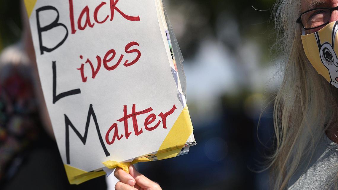 A protester holds up a sign during a Black Lives Matter protest in Sarasota, Florida, on May 12, 2020.