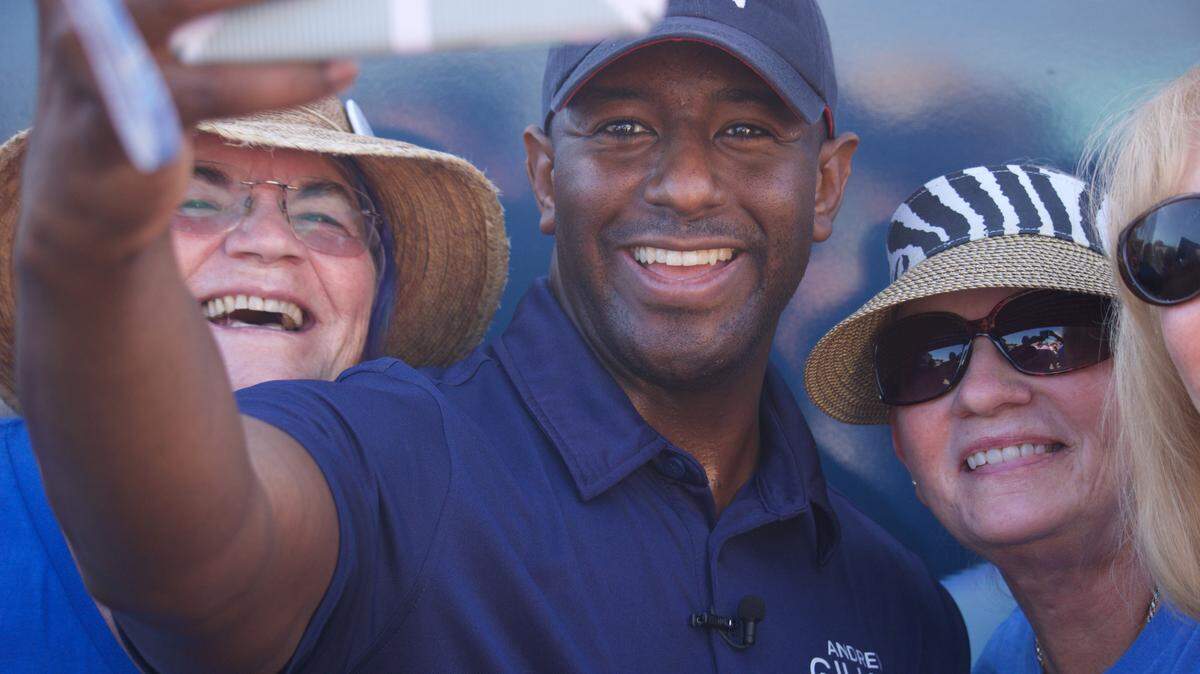 Tallahassee Mayor Andrew Gillum, center, takes a selfie with two supporters outside the office of the Manatee County Supervisor of Elections.