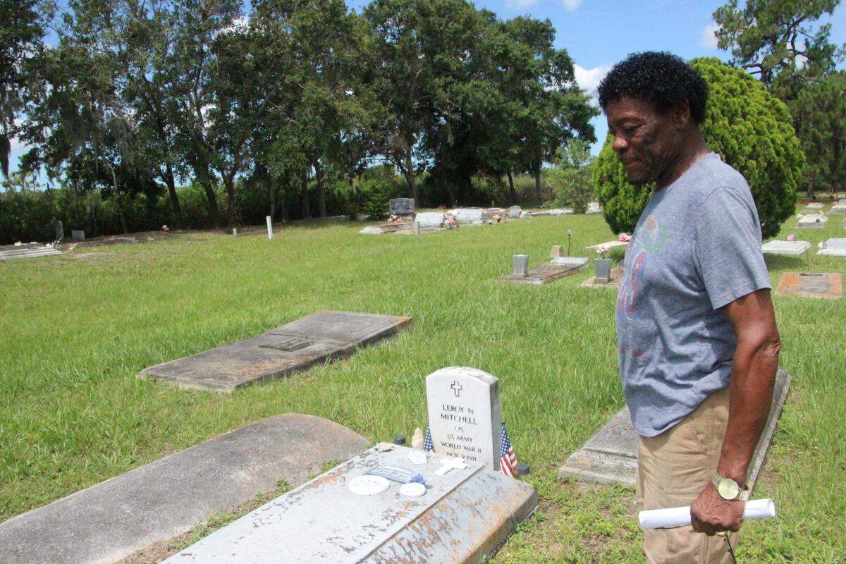 Charles Miller Sr. stands at the grave of his uncle, LeRoy Mitchell, one of many veterans interred at Rubonia Cemetery.