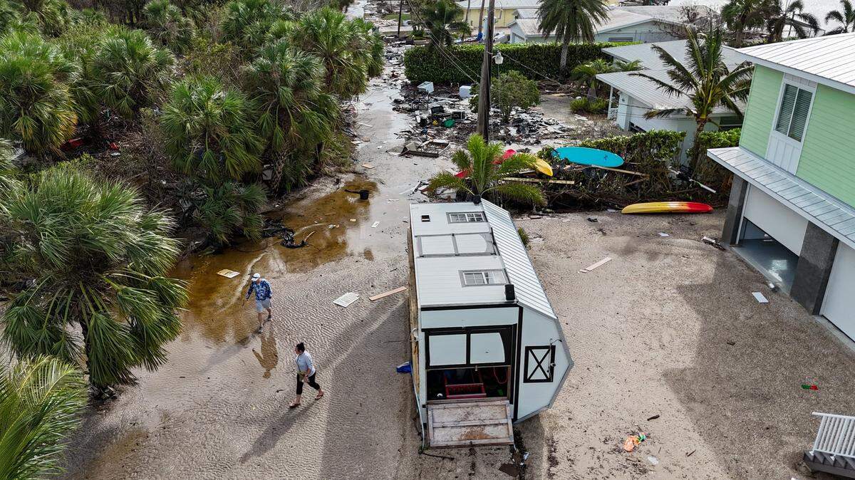 Karre Willis, right, and her husband walk through their neighborhood surveying damage and debris in front of their neighbors’ homes in Charlotte County near Manasota Key on Thursday, Oct. 10, 2024, the morning after Hurricane Milton hit the area.