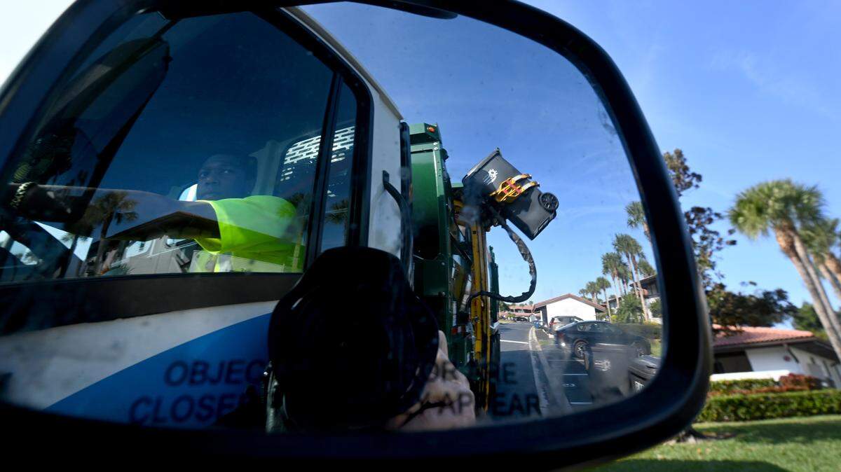 A Waste Pro truck empties trash bins in Valencia Condominiums in Bradenton on Nov. 24, 2025.