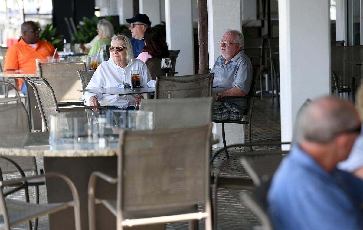 Diners enjoy the fine weather outside as they dine at Palmetto’s Riverhouse. Governor Ron DeSantis announced opening the state’s restaurants to phase 3.