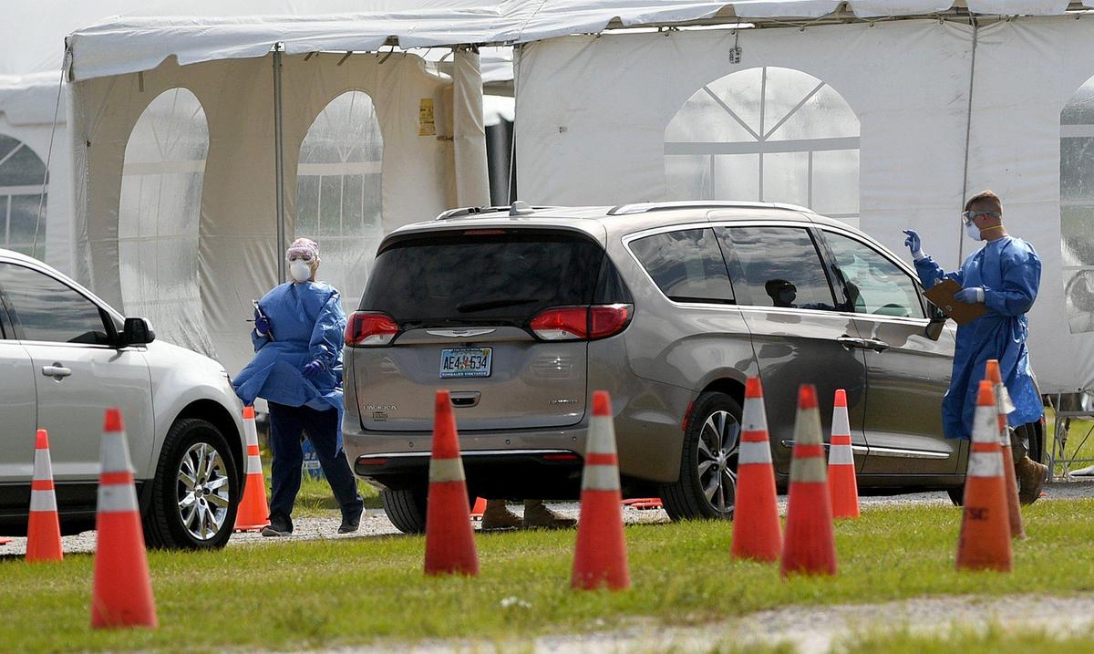 Medical personnel work as cars line up for coronavirus testing at the UTC Mall.