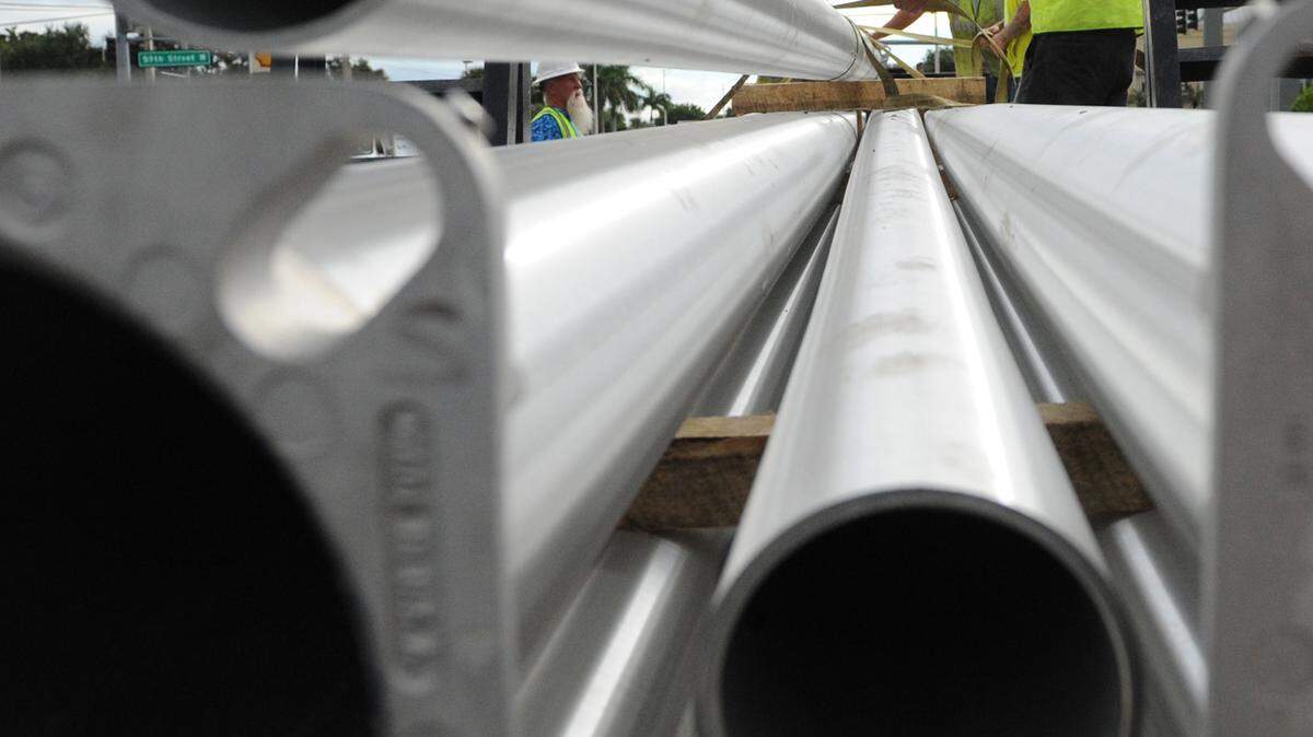 Workers with MSB Services, Bradenton, unload light poles in the 5900 block of Manatee Avenue West on Monday. About 35 new light street lights are to be installed to help illuminate Manatee Avenue's eastbound lanes between 77th Street West and 59th Street West . 
 GRANT JEFFERIES/Bradenton Herald