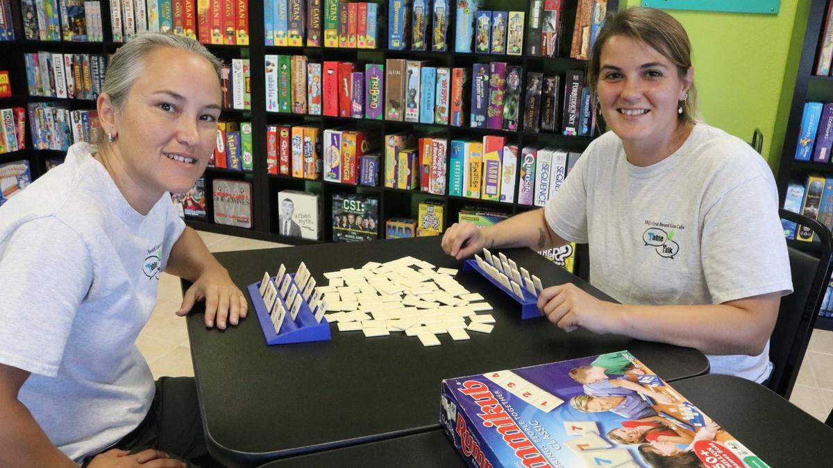 Desiree Ramey, left, and Rachael Sawyer, sitting down to a game of Rummikub, open the area’s first board game cafe, Table Talk SRQ, at 3999 Cortez Road W., on Wednesday.