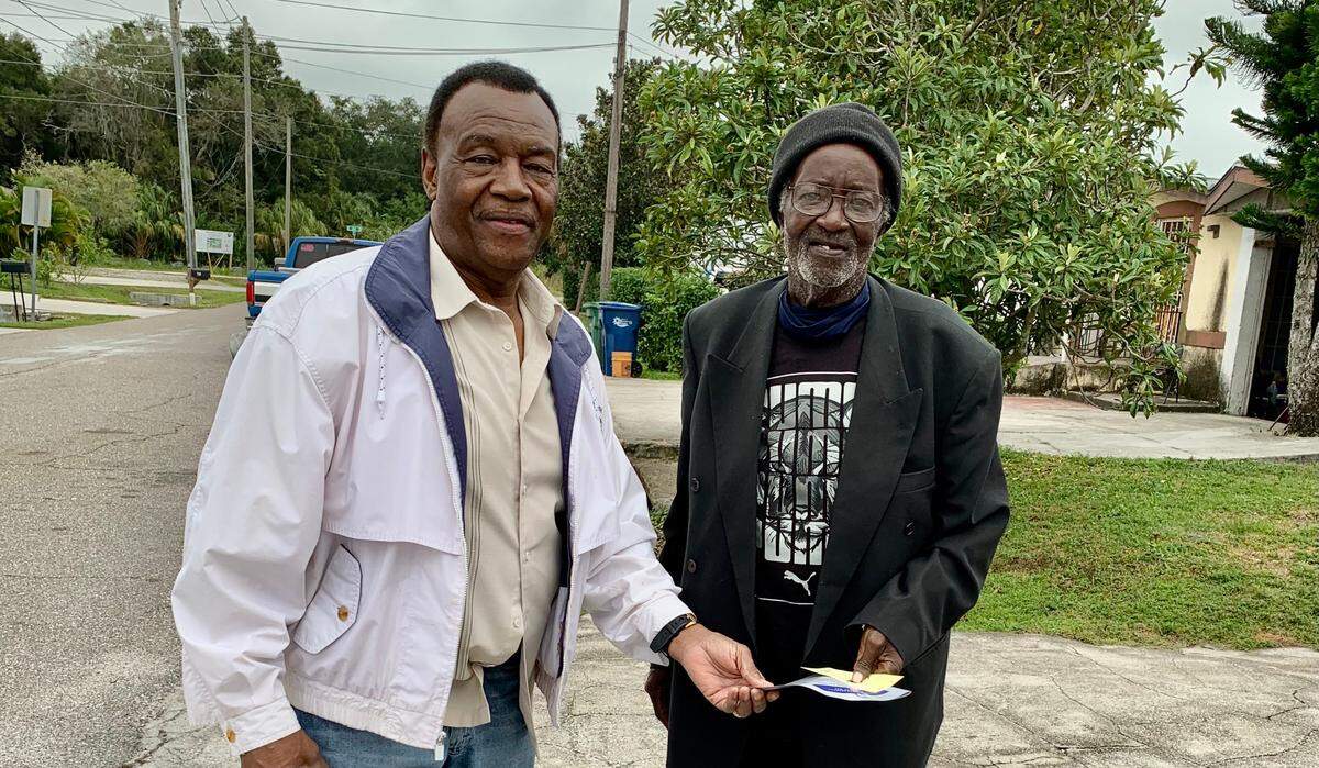 Edward Brown, left, walked his old Palmetto neighborhood on Monday, distributing vouchers to residents for a special Thanksgiving he has planned. One of the recipients was Willie Washington.