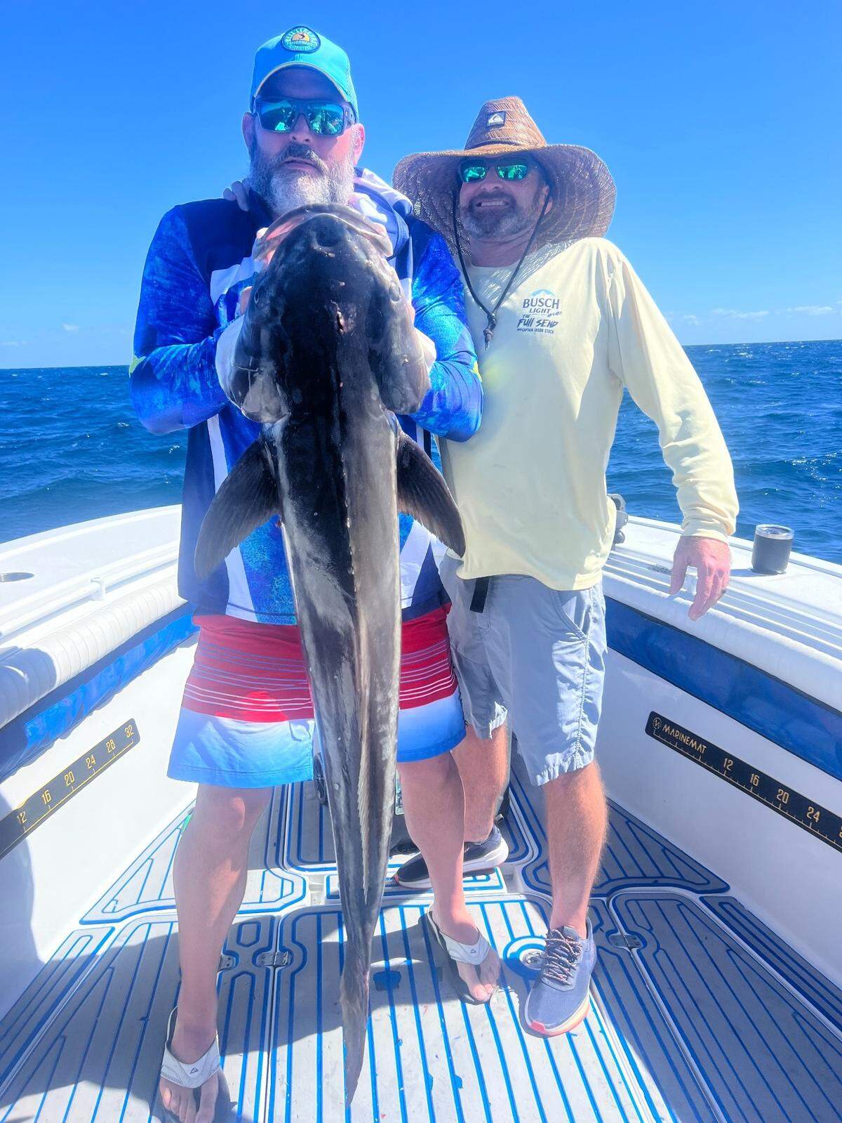 Trey Williams and Brandon Mullenberg hold a cobia caught fishing with Bradenton-based offshore fishing captain Jason Stock.