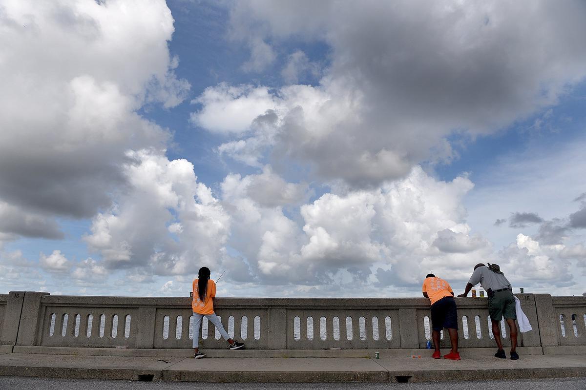 Youth fish with an officer during the Manatee Bridging the Gap 2018 Youth Fishing Tournament on the Green Bridge in Palmetto Thursday morning.