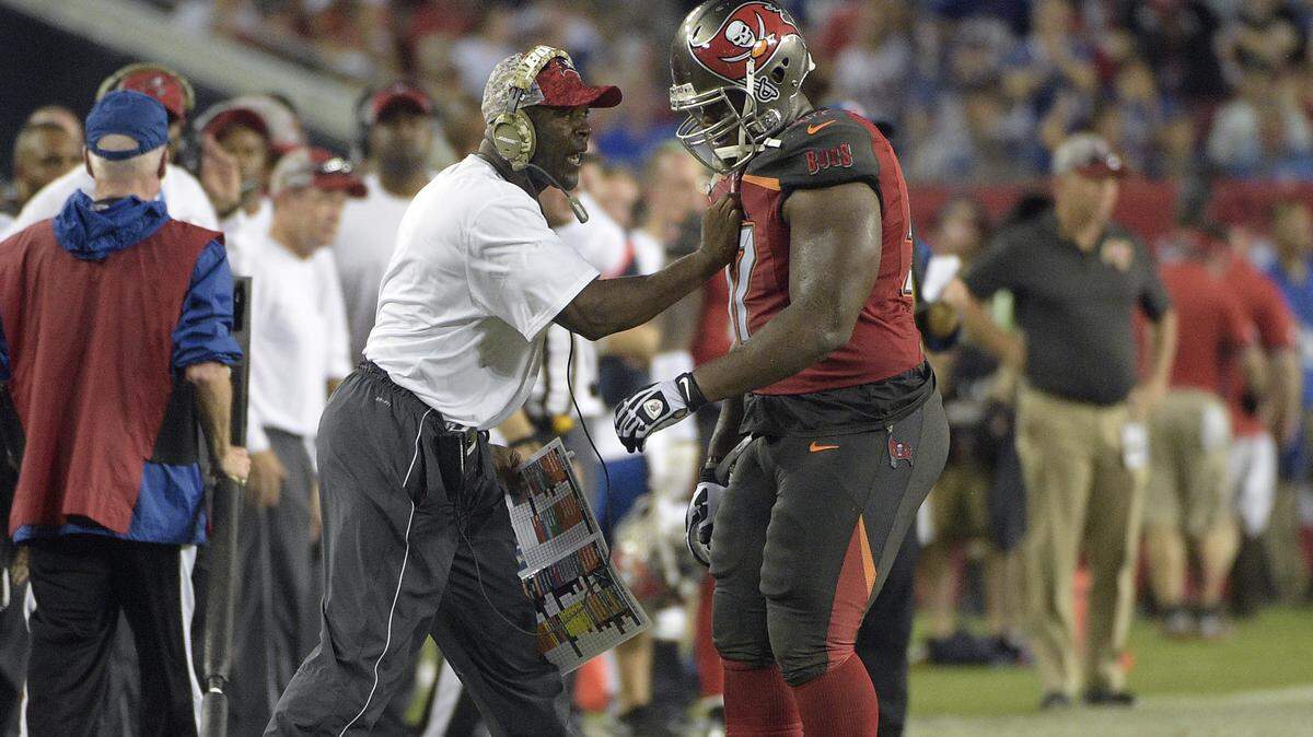 Coach Lovie Smith grabs defensive tackle Akeem Spence after a penalty against the New York Giants during an NFL game in 2015.